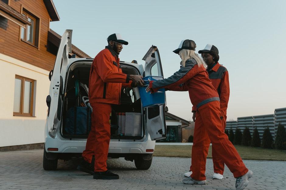 2 Men in Orange Jacket Standing Near White Van