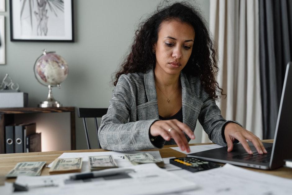 A Woman in Plaid Blazer Using Her Laptop and Mobile Phone