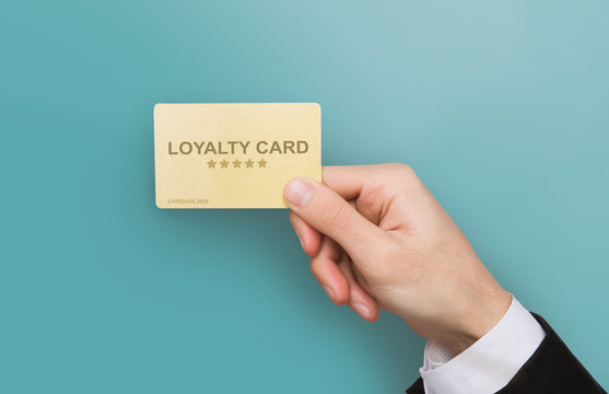 Consumer friendly marketing. Closeup of businessman hand holding loyalty card on blue background. Co