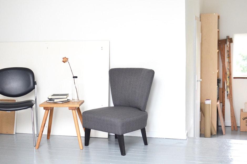 Chairs and table placed near white wall in modern workshop