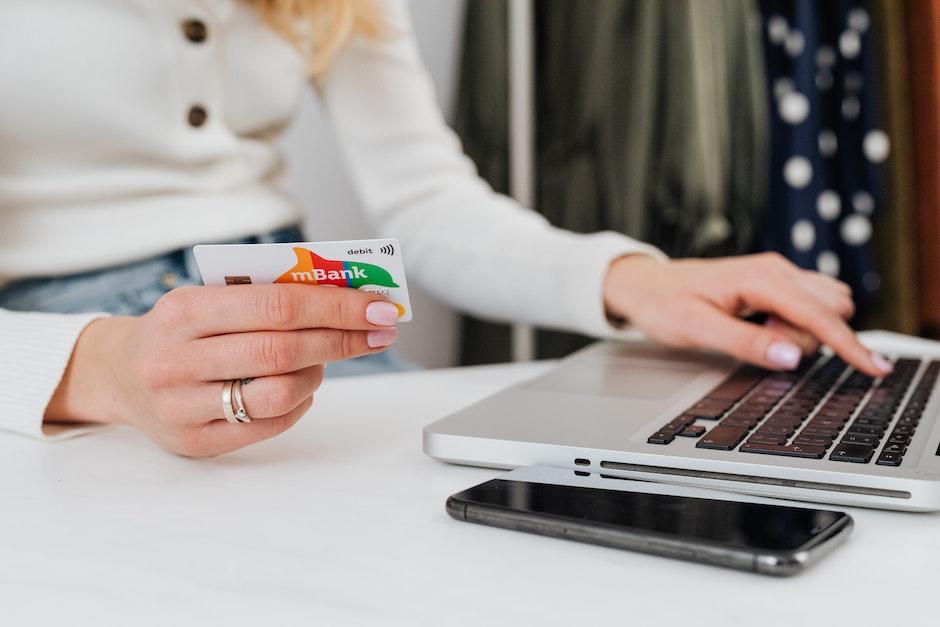 Close-Up Shot of a Person Using a Laptop while Holding a Credit Card