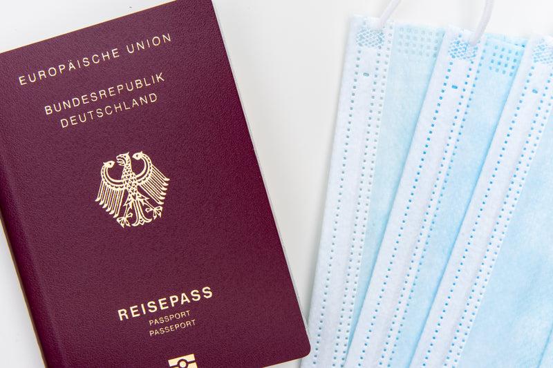 flatlay of a passport and three disposable facemasks