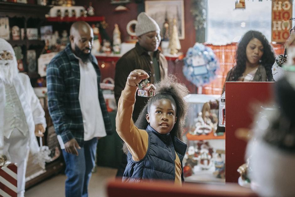 Young African American parents with son and daughter looking for New Year gifts in souvenir shop